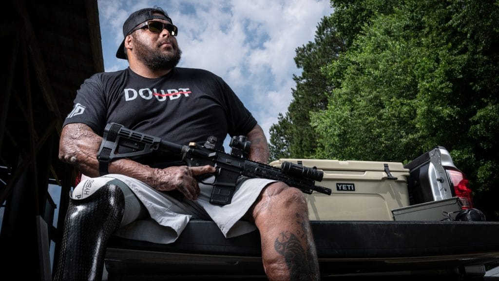 A disable shooter holds a pistol-brace equipped AR-15