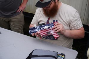 Match officials inspect a 3D-printed gun