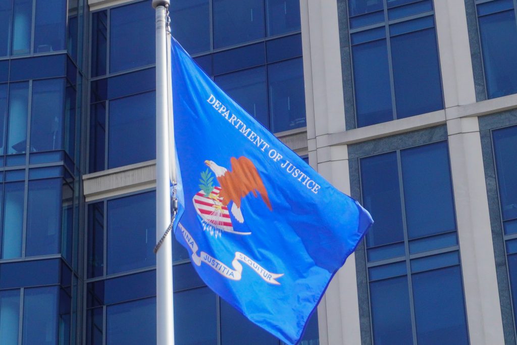 A Department of Justice flag flies in the wind