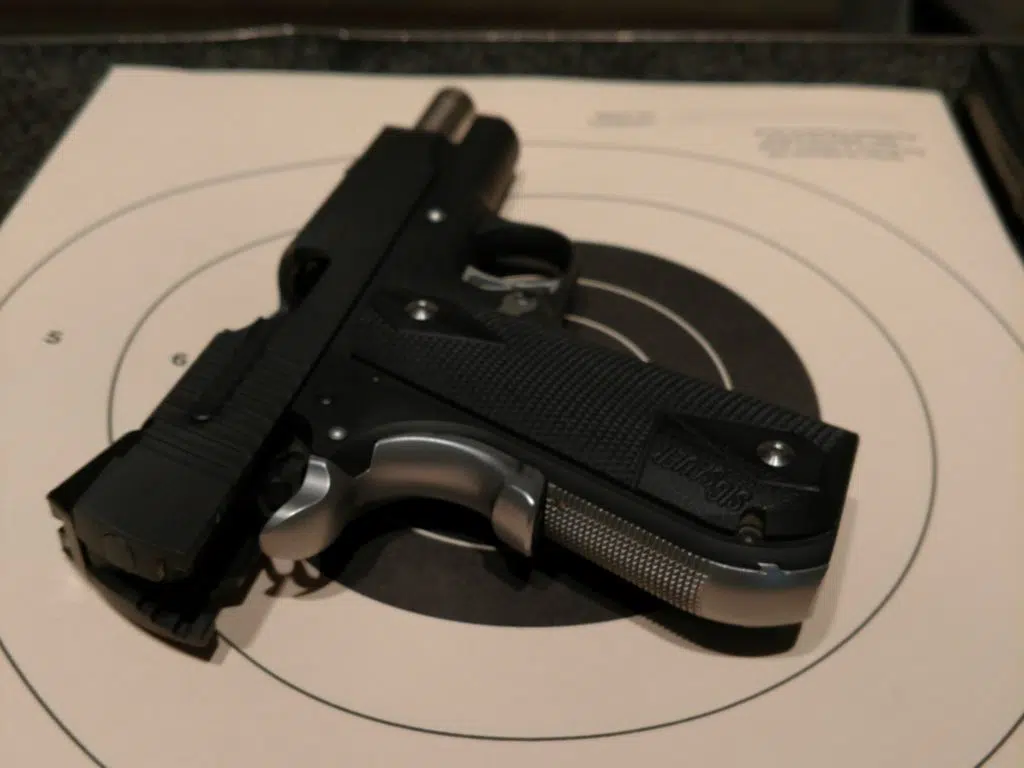 A handgun sits on a target at a gun range