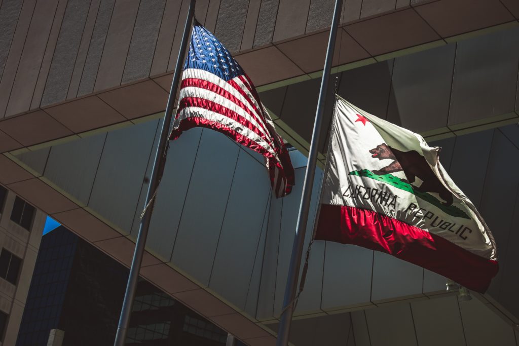 American and California Flags outside of a government building Downtown San Diego on a sunny morning.