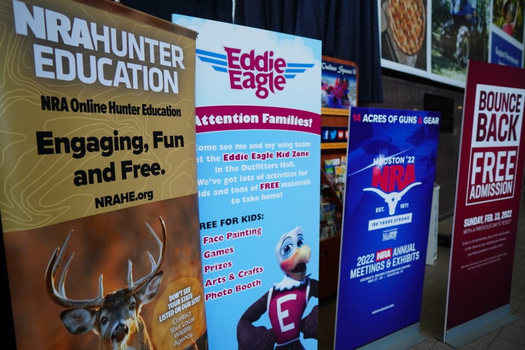 Signs advertise NRA programs at the 2022 Great American Outdoor Show