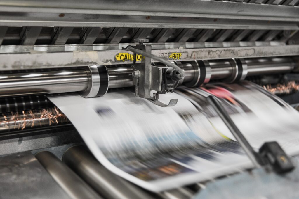 A printing press churns out copies of a newspaper