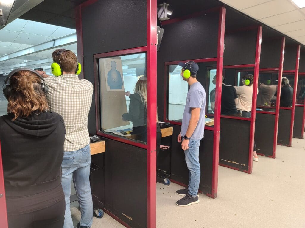 A group of shooters and instructors inside a gun range