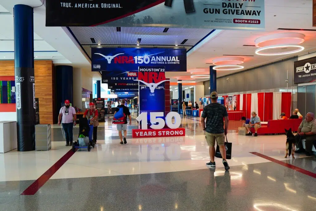 Attendees walk past a sign at the 2022 NRA Annual Meeting in Houston, Texas