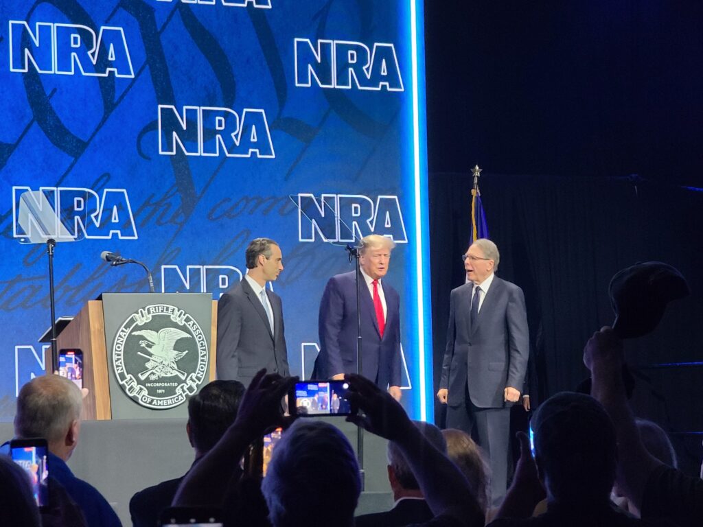 Jason Ouimet, Donald Trump, and Wayne Lapierre on stage at the 2022 NRA Annual Meeting