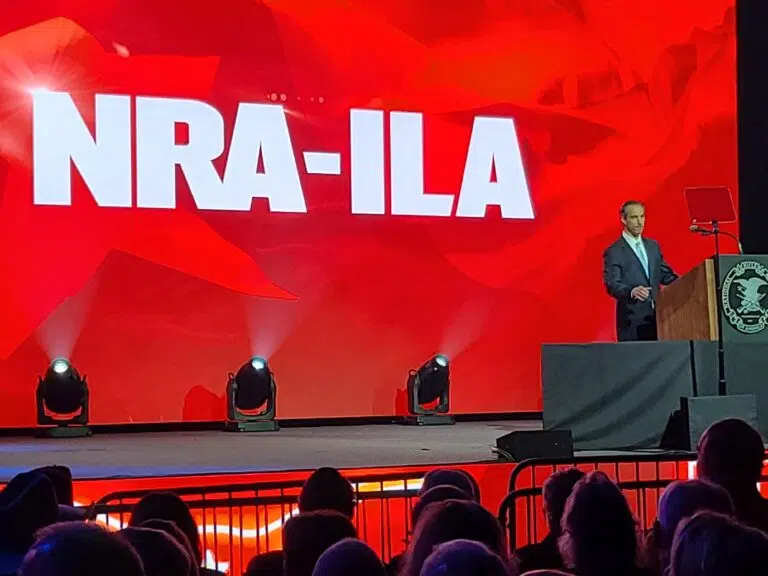 Jason Ouimet speaking behind a podium at the 2022 NRA Annual Meeting