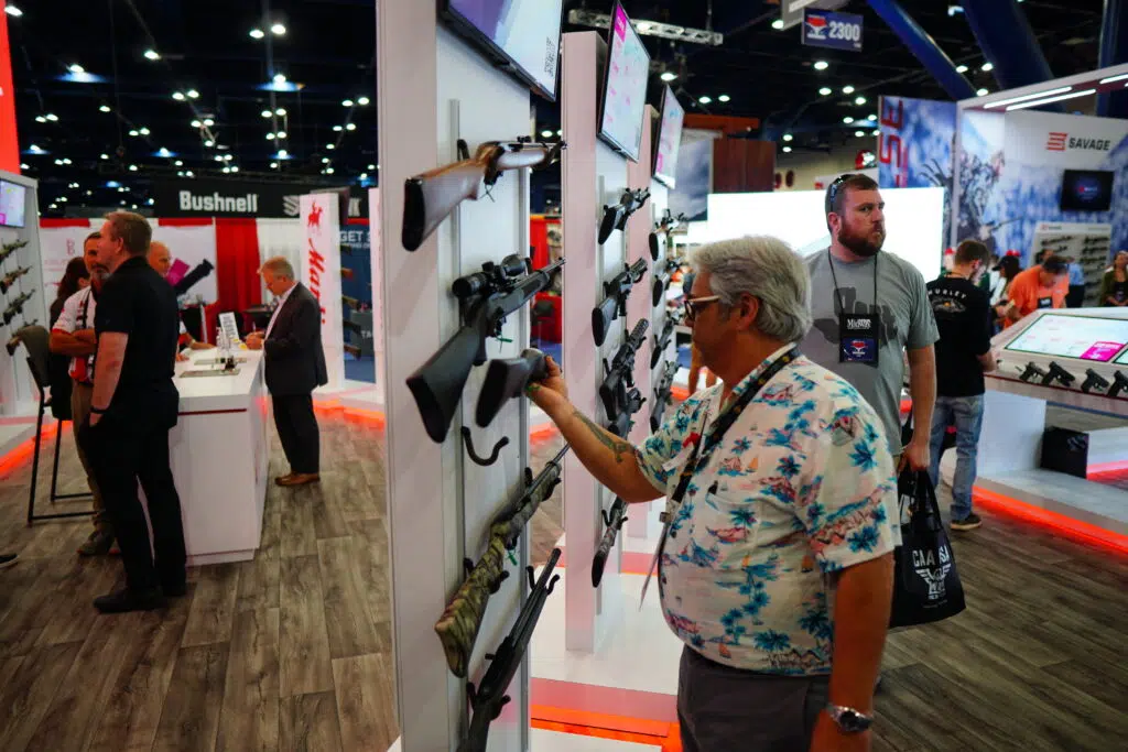 An attendee examining a rifle at the 2022 NRA Annual Meeting