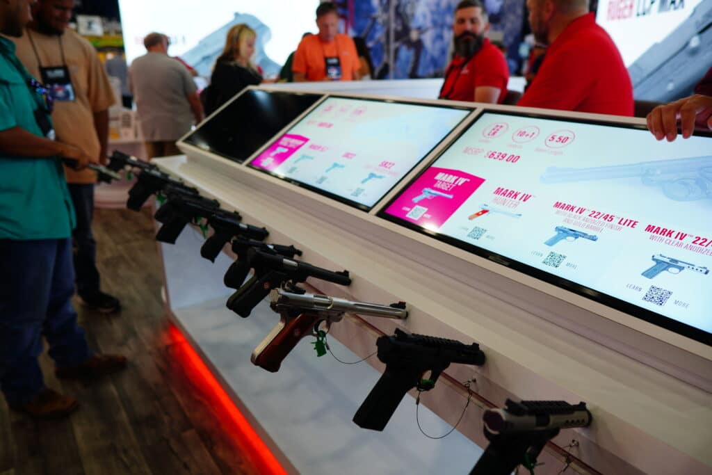 Attendees browsing a pistol display at the 2022 NRA Annual Meeting