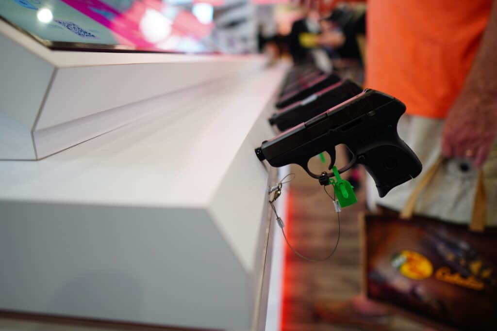 A pistol display with attendees browsing in the background at the 2022 NRA Annual Meeting