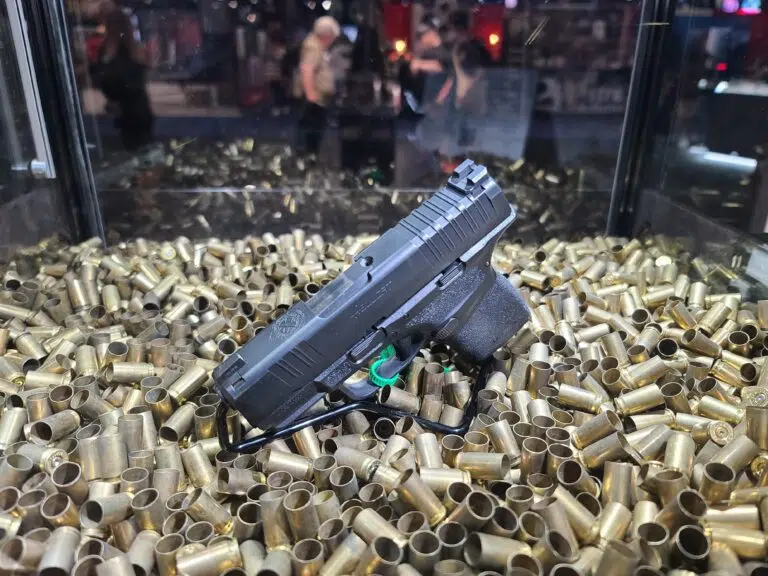 A pistol displayed on top of a pile of bullet casings at the 2022 NRA Annual Meeting