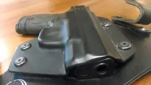 A handgun in a hybrid holster sits on a table