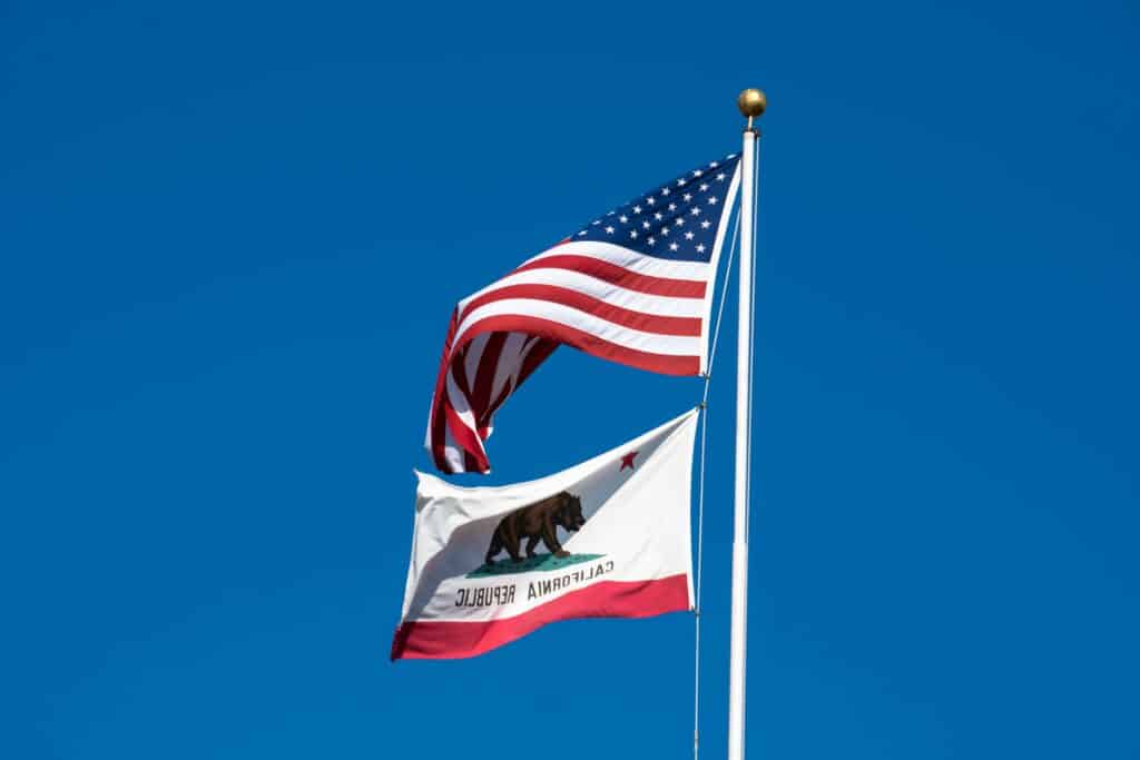 The California state flag flies alongside the US flag