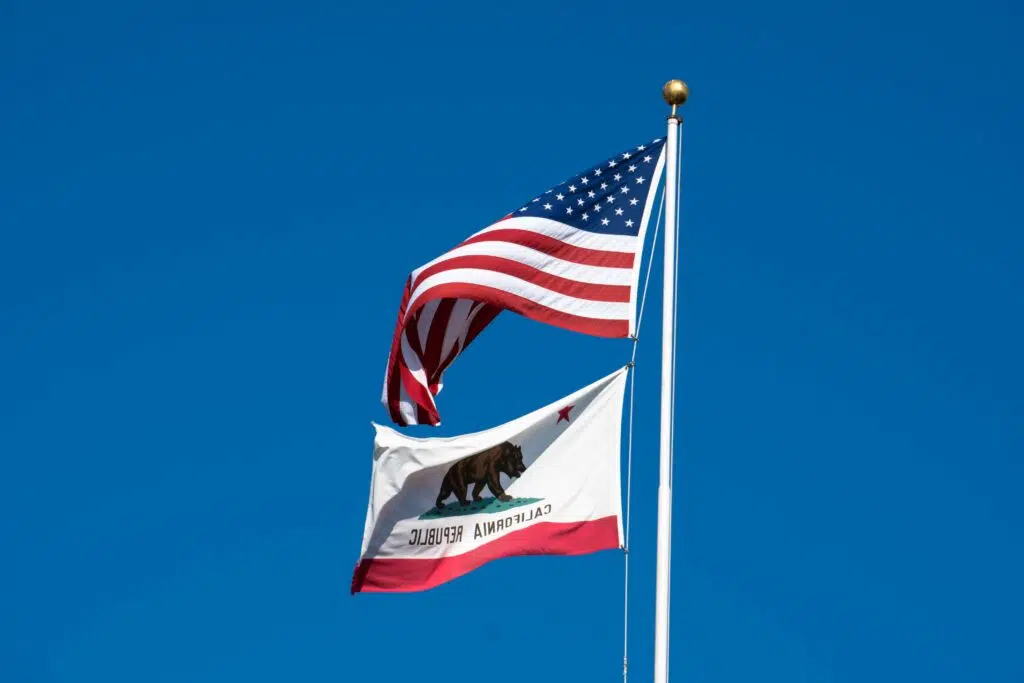 The California state flag flies alongside the US flag