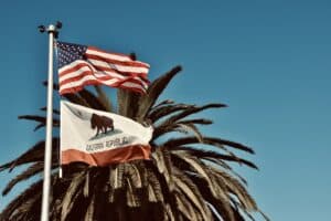 The American and California flags fly in the wind