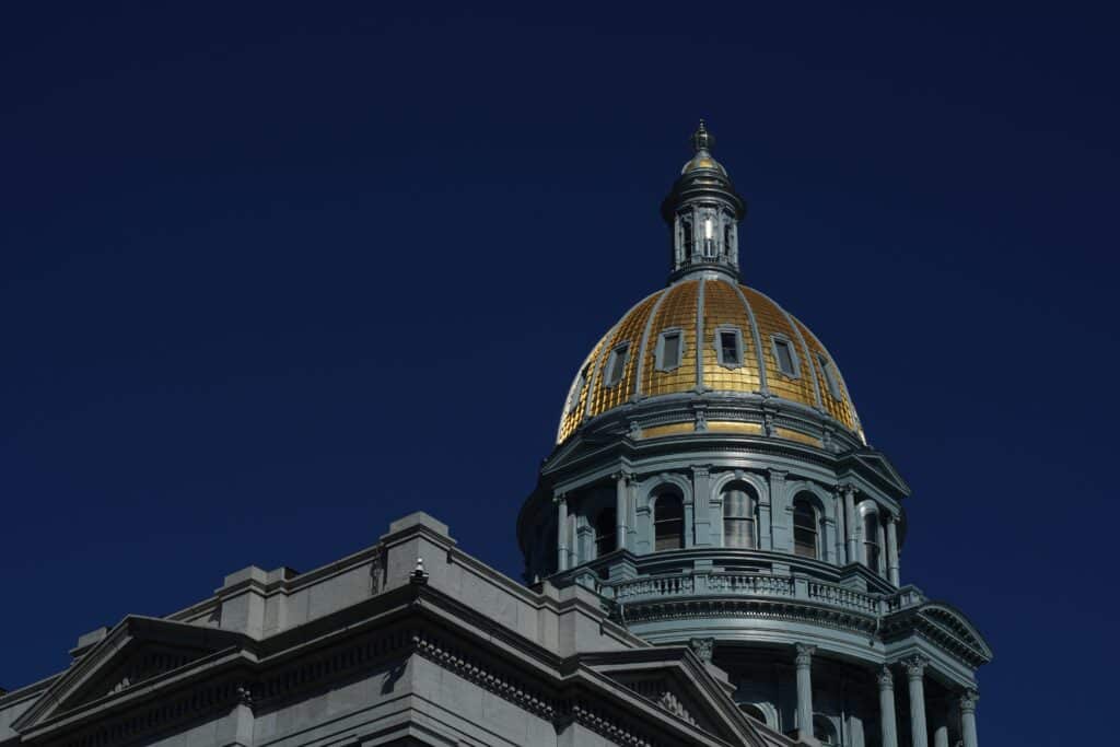 Colorado state Capitol. Gold dome against a deep blue sky.