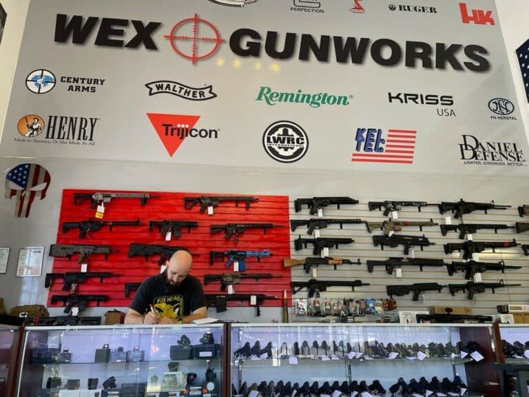 An employee stands before guns on sale at Wex Gunworks in Delray Beach, Florida