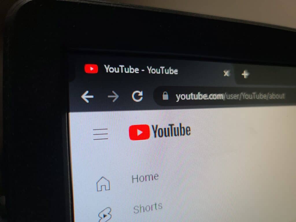 A computer monitor displays the YouTube homepage