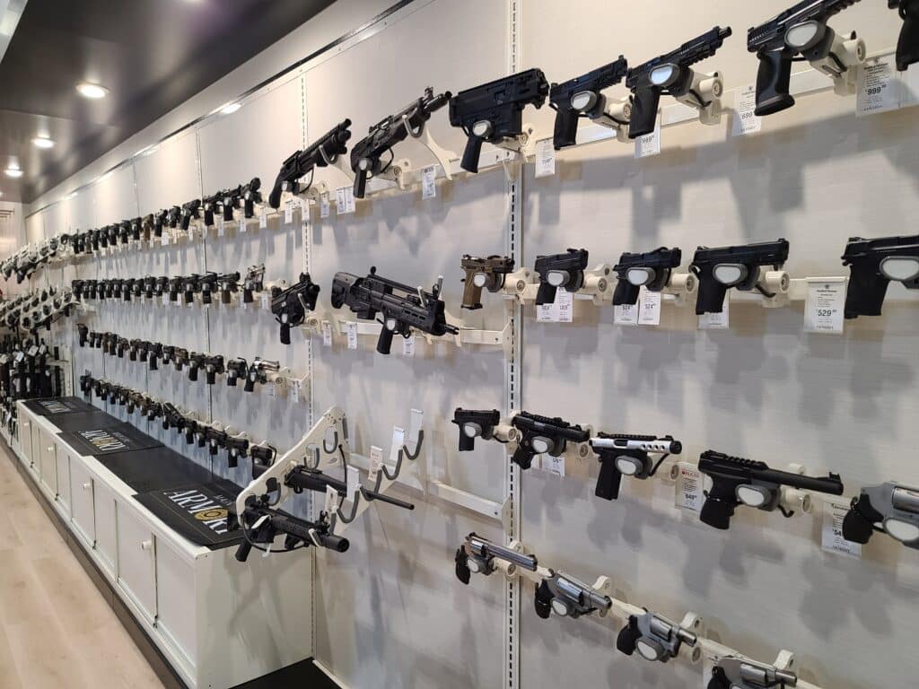 Guns for sale are displayed on a wall at a gun store during April 2023