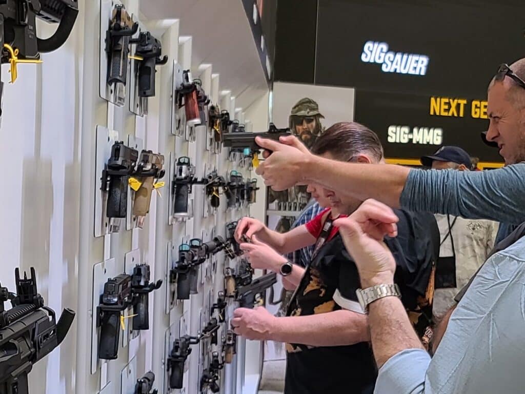 A man examines a gun on display at the 2023 NRA Annual Meeting