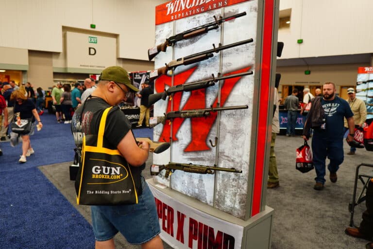 A man examines a display of Winchester firearms at the 2023 NRA Annual Meeting