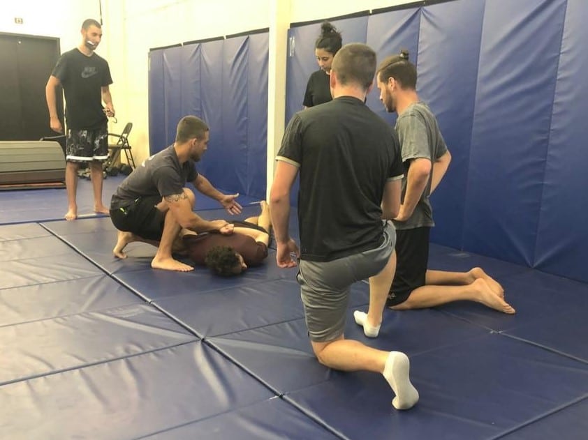 A Magen Am trainer explains how to pin somebody to the ground and handcuff them during a class