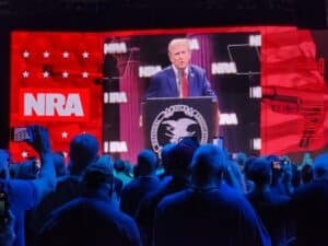 NRA supporters watch as Donald Trump addresses the group's 2024 Annual Meeting